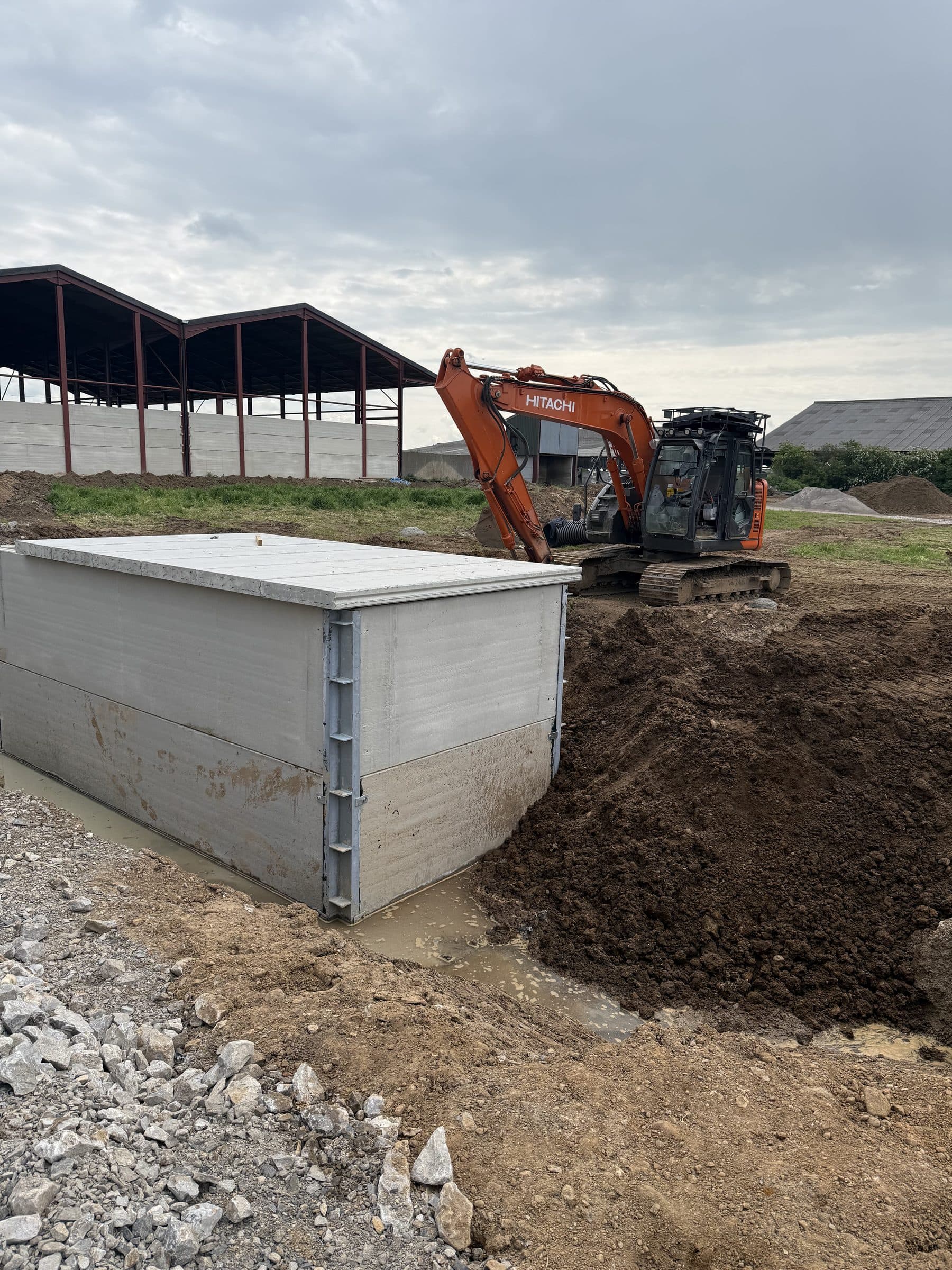 Precast concrete storage tank for an anaerobic digester at East Cowton with a Hitachi excavator alongside