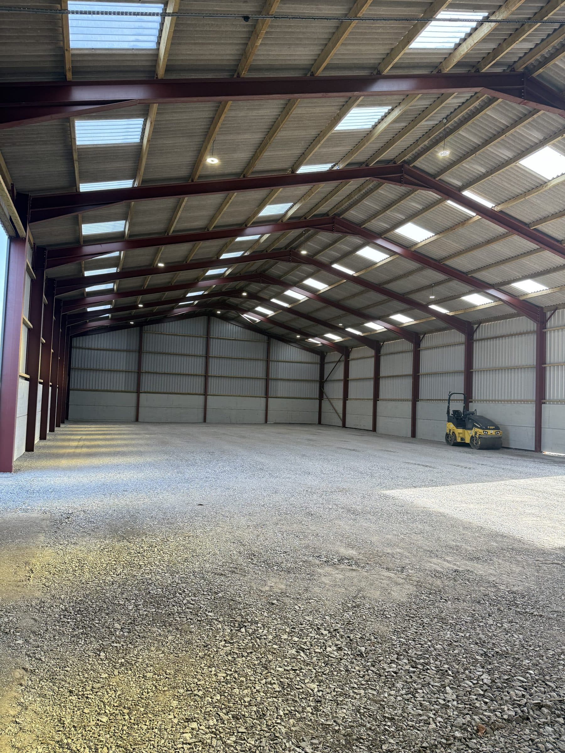 Compacted stone floor inside a new steel-framed agricultural building at Bedale with a roller in the corner